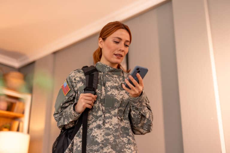 United States Army soldier woman checking her smartphone at home